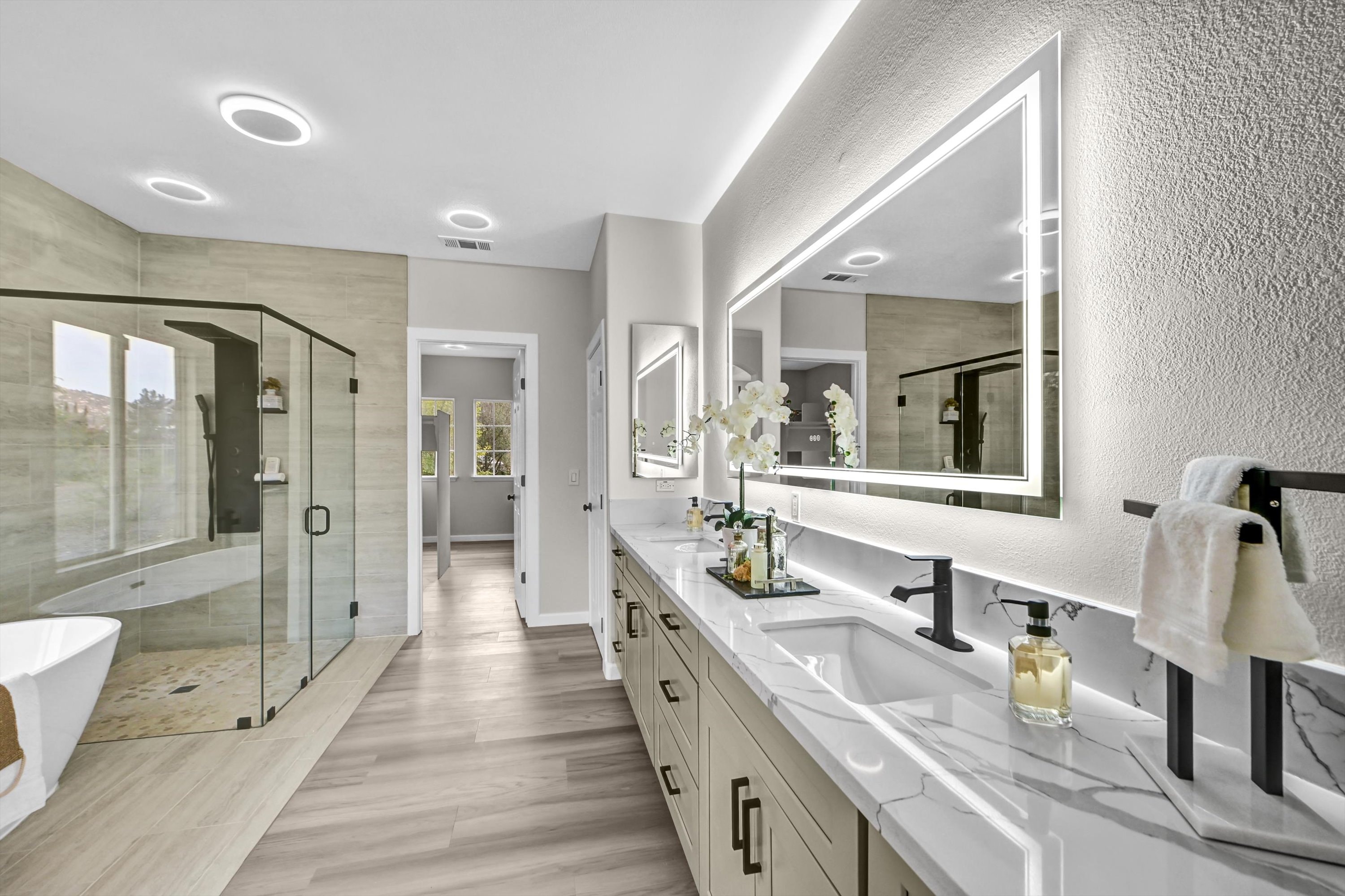 Master bathroom renovation with freestanding tub and LED mirrors